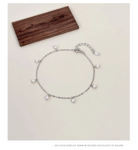 Dettaglio del bracciale in argento S925 con perle e chiusura regolabile su sfondo beige
