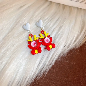 Détail de boucles d'oreilles dragon rouge mignonnes avec clous en forme de cœur