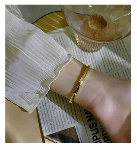 Detailed macro view of 18k gold plated stainless steel bangle with geometric diamond patterns