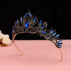 Close-up of vintage gold crown featuring blue pear-shaped rhinestones and black crystals