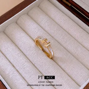 Golden H-letter open ring with zircon inlay and mother of pearl on a beige luxury jewelry box