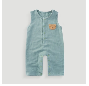 Detail of baby cotton gauze bodysuit with cute bear patch and snap button closure