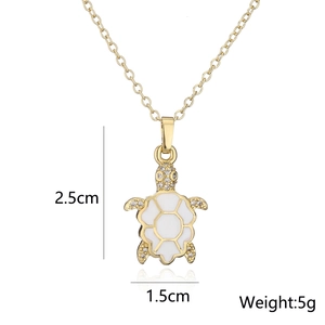 Detalle del colgante de tortuga con esmalte blanco y dimensiones de 2,5cm por 1,5cm