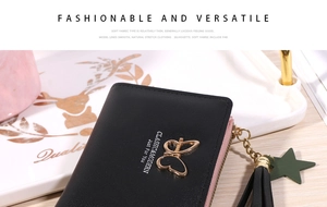 Detailed macro shot of a black short wallet with a gold butterfly and fringe zipper