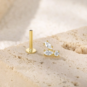 Macro detail of a gold S925 silver piercing stud with clear marquise leaf crystals