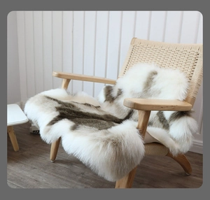 Detail of plush faux reindeer fur rug with brown and white pattern on a wooden chair