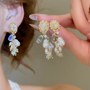 Makroaufnahme goldener Quastenohrringe mit Perlen und Kristallen im Vintage-Hofstil