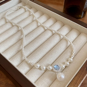 Collana di perle vintage con ciondolo di pietra blu in una scatola portagioie beige