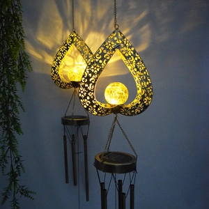 Solar powered heart wind chimes with warm crackle glass ball casting intricate patterns