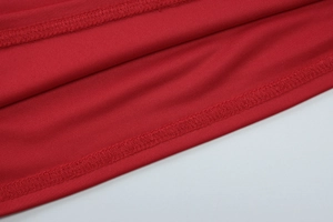 Vue macro détaillée de la texture du tissu tricoté rouge avec couture de l'ourlet