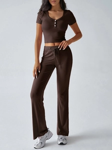 Dettaglio del crop top marrone a costine con bottoni e pantaloni svasati coordinati