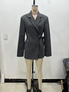 Détail du blazer gris foncé à fines rayures avec ceinture à nouer et revers en pointe