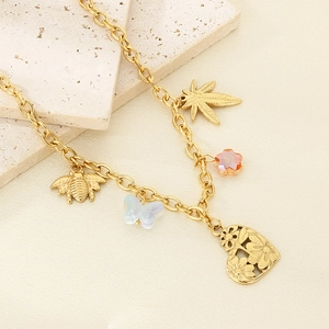 Detailed shot of gold necklace featuring leaf, bee, butterfly, and floral heart pendants