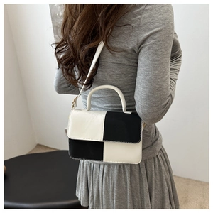 Dettaglio della borsa bicolore in bianco e nero con eleganti finiture dorate