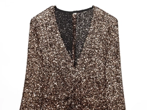 Detail view of V-neckline on champagne gold sequin dress with shoulder pads and size S label