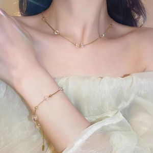 Detailed view of elegant gold link chain jewelry set with iridescent square crystal beads