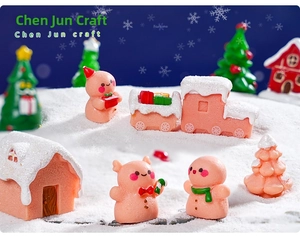 Macro detail of festive pink gingerbread man and snowy resin cottage figurines