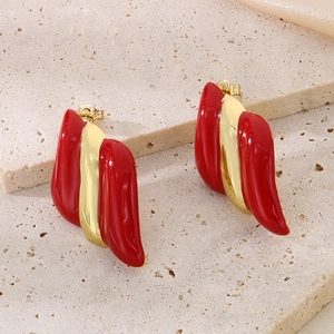 Gros plan détaillé de boucles d'oreilles émaillées rayées dorées 18 carats sur pierre