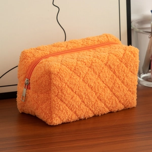 Detail of orange sherpa fleece pencil case with diamond quilted pattern and metal zipper