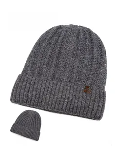 Detail of gray ribbed knit beanie showing the snowflake leather patch and back view