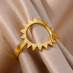 Detail view of 18k gold sunburst ring with hammered texture on champagne silk