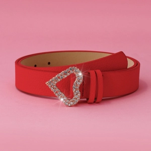 Close-up of red leather heart buckle belt with sparkling rhinestones on pink background