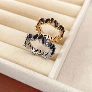 Detail of gold and silver rings with black rectangular stones and small white diamonds