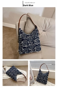 Detail of blue denim tote bag with textured frayed flower pattern and leather strap
