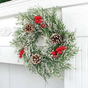 Couronne de Noël avec baies rouges, pommes de pin et aiguilles de pin enneigées