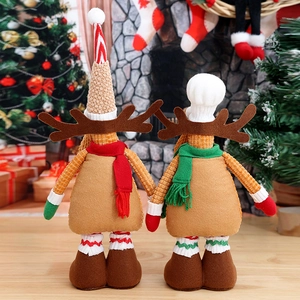 Christmas reindeer plush dolls with red scarves in a warm festive home fireplace setting