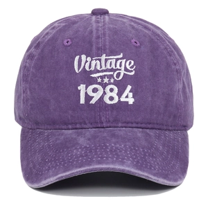 Close-up of white 1984 Vintage embroidery on a purple washed cotton baseball cap