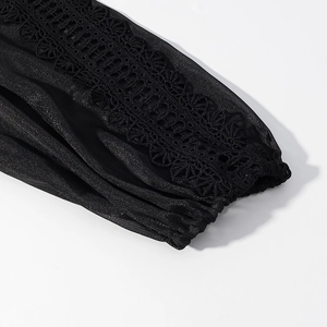 Detail shot of the black long-sleeve dress with elegant lace patchwork and elastic cuffs