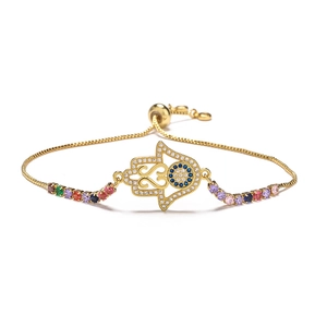 Close-up of 18K gold Hamsa Hand bracelet with evil eye and rainbow zircons detail
