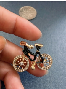 Macro shot of vintage bicycle brooch in black gold finish with sparkling rhinestones