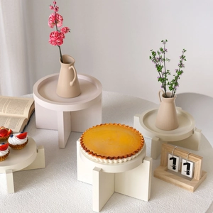 Detailed view of cream resin display stands with round trays in a lifestyle setting