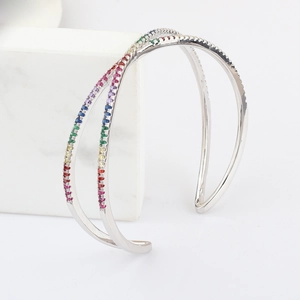 Macro view of crossover silver bracelet featuring rainbow-colored zircon pavé setting