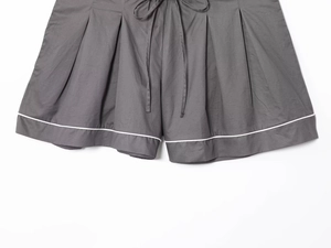 Detail of dark gray cotton shorts with white contrast trim and drawstring waist closure