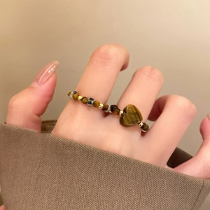 Detailed macro view of heart-shaped tiger eye stone and beaded elastic stretch ring