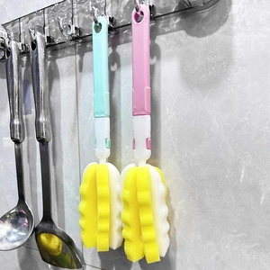 Long-handle baby bottle sponge brushes in blue and pink hanging on a kitchen wall hook