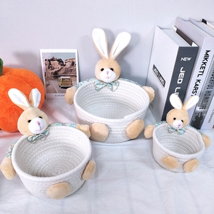 Three sizes of cream woven cotton storage baskets with cute plush rabbit decorations
