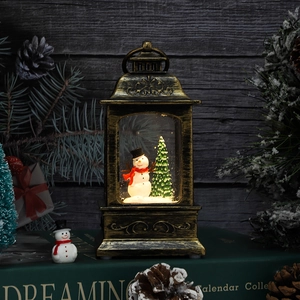 Close-up of a festive Christmas lantern with a snowman scene and warm internal lighting