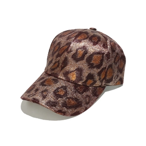 Detail of trendy baseball cap with leopard print and metallic golden shimmer texture