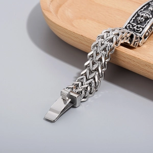 Macro shot of silver titanium steel bracelet featuring vintage engraved floral clasp