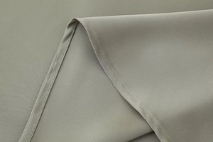 Detail of grey-green satin midi skirt showing fine stitching and smooth fabric texture