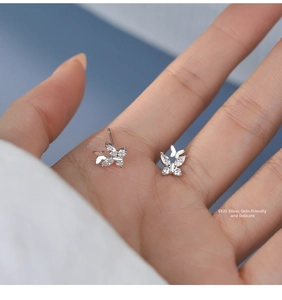 Macro view of double butterfly S925 silver stud earrings with sparkling cubic zirconia