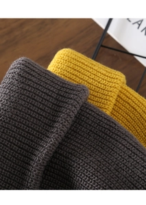 Close-up of thick ribbed knit texture in dark grey and bright yellow wool yarn