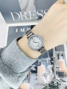 Close-up of a ladies' silver quartz watch featuring a rhinestone bezel and steel strap