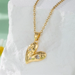 Elegant gold zircon heart pendant necklace with O-chain on white stone and floral background