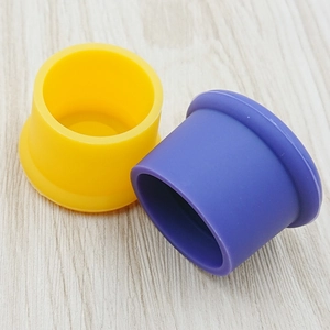 Close-up of yellow and purple food-grade silicone bottle caps on wood background