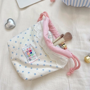 Detail of floral lace edge on drawstring makeup bag with star patterns and pink ropes